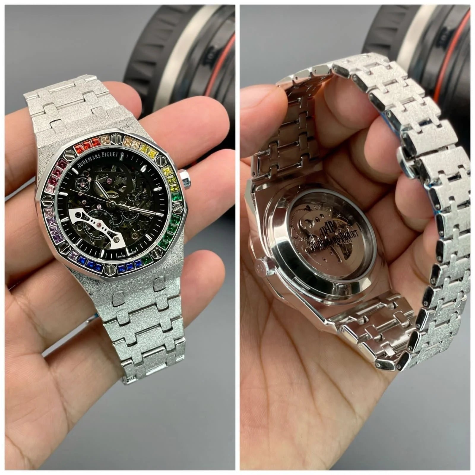 Audemars Piguet Royal Oak watch with a gem-set rainbow bezel, silver case, and a round dial with open-back machinery visible.