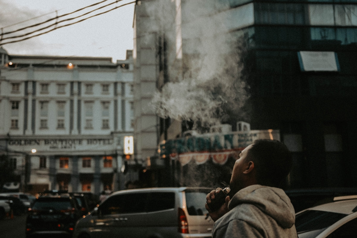 a man smoking a cigarette on a city street